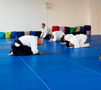 Eine Gruppe im Aikido Training, die sich vor dem Trainer verbeugen.